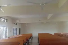 Редици дървени чинове в учебна зала